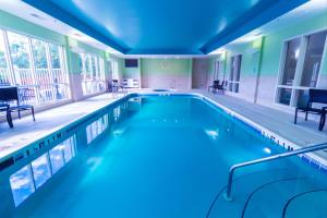 ein großer Pool mit blauer Beleuchtung in einem Gebäude in der Unterkunft Holiday Inn Express Hotel & Suites Crestview South I-10, an IHG Hotel in Crestview