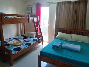 een slaapkamer met 2 stapelbedden en een blauw bed bij Kassel residence Mhavic Family room good for 5guest in Manilla
