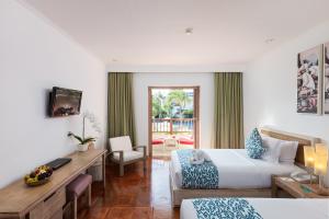 a hotel room with two beds and a desk at Blu-Zea Resort by Double-Six in Seminyak