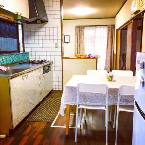 a kitchen with a table and chairs in a kitchen at Aoshima in Kisaki