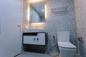 a bathroom with a toilet and a sink and a mirror at CA&SA Serviced Apartment in Phnom Penh