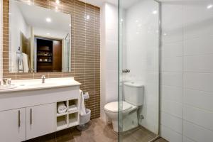 a bathroom with a toilet, sink, and shower at Mercure Centro Port Macquarie in Port Macquarie