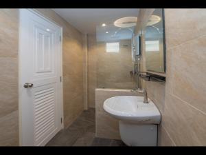 a bathroom with a white sink and a mirror at Tuk’s Sports Bar in Pattaya Central