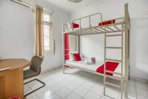 a room with two bunk beds and a desk at RedDoorz Hostel @ Feliz Noche Cengkareng in Jakarta