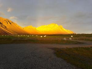 a mountain range with a rainbow in the sky at Sefdalur Studio Apartment in Höfn