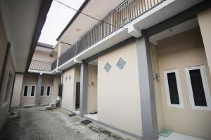 an empty hallway of a building with doors and windows at RedDoorz near Bundaran Kecil Palangkaraya in Palangkaraya