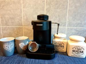 a coffee maker sitting next to two coffee cups at Spectacular Home in Ploieşti