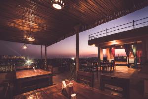 a restaurant with tables and chairs on a rooftop at Tripli Hotels Prithvi Palace in Jaisalmer