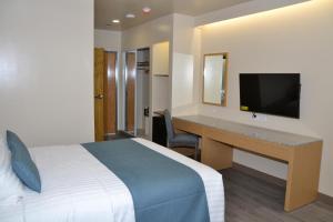 Un pat sau paturi într-o cameră la West Plaza Hotel at Lebuu Street