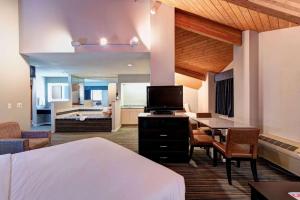 a hotel room with a bed and a desk with a television at SureStay Plus Hotel by Best Western Redding in Redding