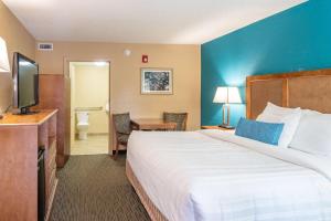 a hotel room with a large bed and a television at Best Western Charleston Inn in Charleston