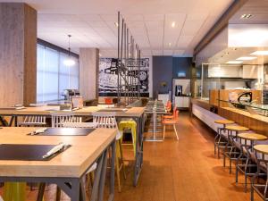 a restaurant with tables and chairs and a kitchen at ibis Recife Boa Viagem in Recife