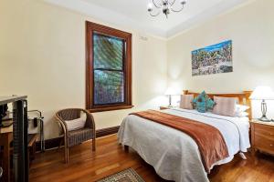 a bedroom with a bed, a desk, and a painting on the wall at The Classic Villa in Christchurch