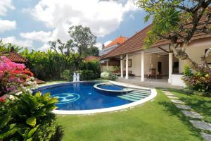 a swimming pool in the yard of a house at Heliconia Villa in Seminyak