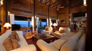 a living room with white couches and a tv at Tassana Pra in Bophut 