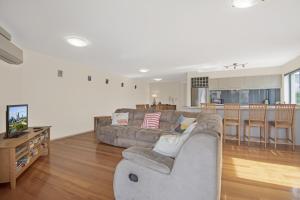 a living room with a couch and a kitchen at Breakwater Views by Kingscliff Accommodation in Cabarita Beach