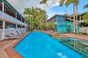 a swimming pool with lounge chairs next to a building at Arts Factory by Nomads in Byron Bay