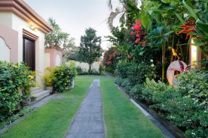 un jardín con una pasarela junto a una casa en Heliconia Villa, en Seminyak