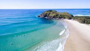 an aerial view of a beach with people in the water at Caba Shack by Kingscliff Accommodation in Cabarita Beach