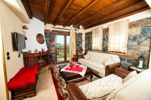 a living room with a couch and a table at Eva Guesthouse in Palaios Agios Athanasios