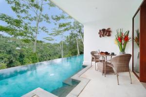 une maison dotée d'une piscine avec une table et des chaises dans l'établissement The Hidden Paradise Ubud - CHSE Certified, à Ubud