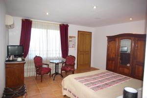 a bedroom with a bed and a table and chairs at Le Mas de l'Amandier in Saint-Saturnin-lès-Avignon