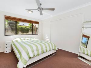 - une chambre blanche avec un lit et un miroir dans l'établissement Casuarina Escape by Kingscliff Accommodation, à Casuarina