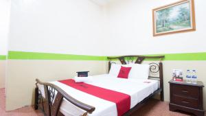 a bedroom with a bed with a red and white blanket at RedDoorz at Praferosa Resort Hotel Calamba in Calamba +33 photos