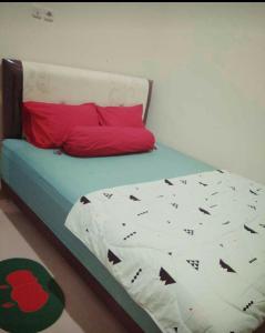 ein Bett in einem Zimmer mit einem roten Kissen und Werbung in der Unterkunft Full House Emerald Villa i6 2 BR Near JTP 3 in Batu
