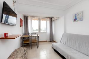 Schlafzimmer mit einem Bett, einem Schreibtisch und einem Tisch in der Unterkunft Apartamento Boliche in Benimagrell