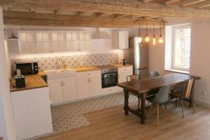 a kitchen with a wooden table and a dining room at Le gite d'à côté in Fons-outre-Gardon