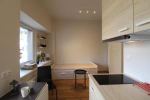 a small kitchen with a desk and a bed at El Castillo Apartments in Tallinn +6 photos