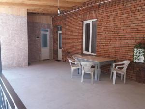 a patio with a table and chairs and a brick wall at Apartament LashaGiorgi in Borjomi