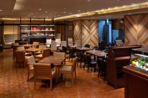 a restaurant with tables and chairs and a bar at Shibuya Tokyu REI Hotel in Tokyo