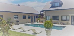 a house with a swimming pool in front of a house at Stoneridge farm in Plettenberg Bay
