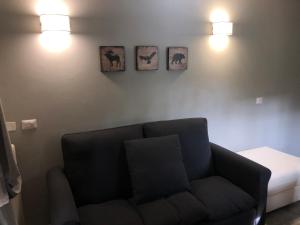 a living room with a couch and three pictures on the wall at Appartamento Ducale Val Di Luce in Abetone