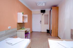 a room with two beds and a sink and a desk at Podolski Parus in Kyiv