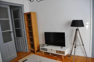 een kamer met een televisie op een stand met een lamp bij Puente sobre el Ebro in Logroño