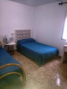 a bedroom with two beds and a table and a window at Arroyo de la Miel centro in Benalmádena