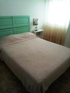 1 dormitorio con 1 cama grande y cabecero azul en Arroyo de la Miel centro, en Benalmádena