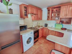 a kitchen with wooden cabinets and a washer and dryer at Bogate Studio in Żywiec