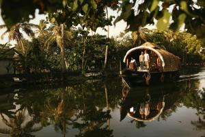 eine Gruppe von Menschen auf einem Boot im Wasser in der Unterkunft Spice Coast Cruises - Houseboat in Alappuzha