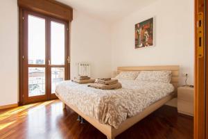 - une chambre avec un lit et des serviettes dans l'établissement Bright house with 2 bedrooms & a unique terrace, à Bergame