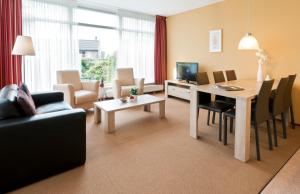 a living room with a table and a dining room at Appartementen Hotel Geuldal in Epen