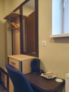 a table with a mirror and a blue chair at Šolena in Alytus