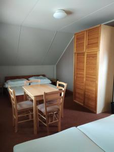 a room with a table and chairs and two beds at Apartmany Bobule in Deštné v Orlických horách