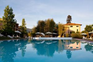 ein Schwimmbecken mit blauem Wasser vor einem Gebäude in der Unterkunft Hotel Villa Cappugi in Pistoia