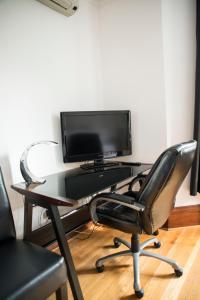 een computerbureau met een monitor en een stoel bij Le Widor in Québec