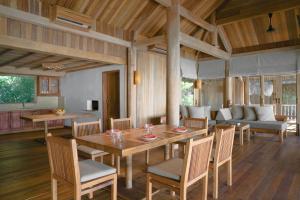 - une salle à manger avec une table, des chaises et un canapé dans l'établissement Six Senses Ninh Van Bay, à Baie de Ninh Van