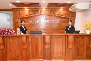 duas pessoas sentadas num balcão num tribunal em Dragon Phoenix Hotel em Mandalay